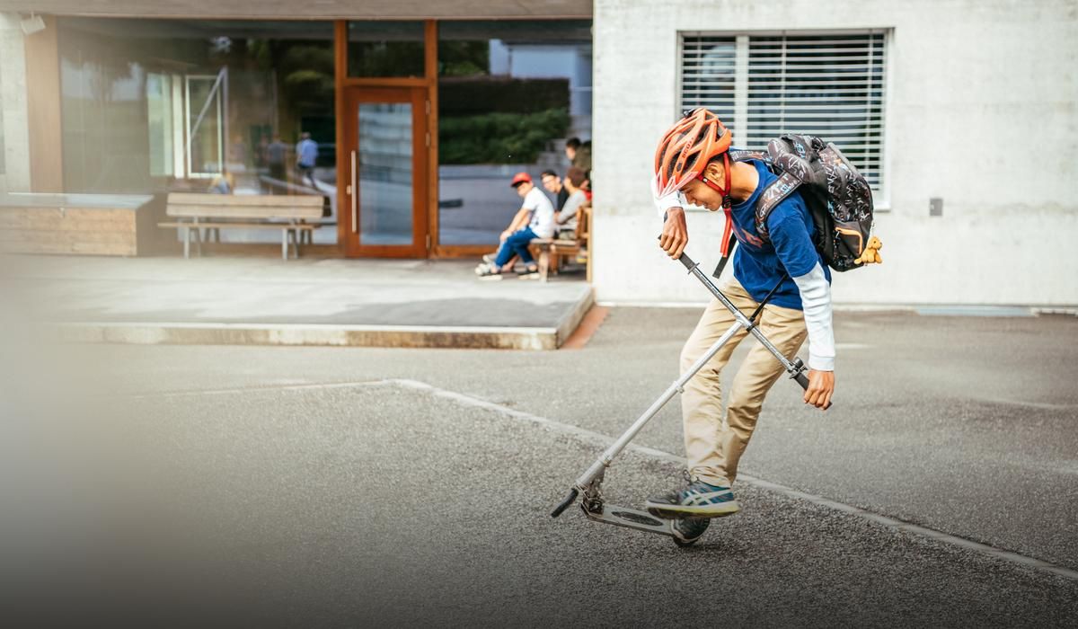 SHScharans-Startseite-Schüler mit Trottinette vor Schuleingang
